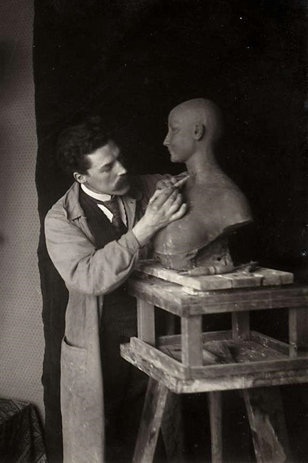 beeldhouwer / kunstenaar Frans Werner aan het werk in zijn atelier.
              <br/>
              onbekend, 1917
