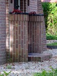 Links en rechts van de voordeur imposante cilindervormen.
              <br/>
              Gert-Jan Lobbes, 2023