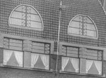 Detail van het dak met de afgetopte paraboolramen. Ook de vlaggenmast en vlaggenmasthouder zijn goed zichtbaar.
              <br/>
              Het Utrechts Archief, 1924
