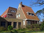Voormalige conciërgewoning en zijkant schoolgebouw, met links de nieuwbouw.
              <br/>
              Gert-Jan Lobbes, 2024