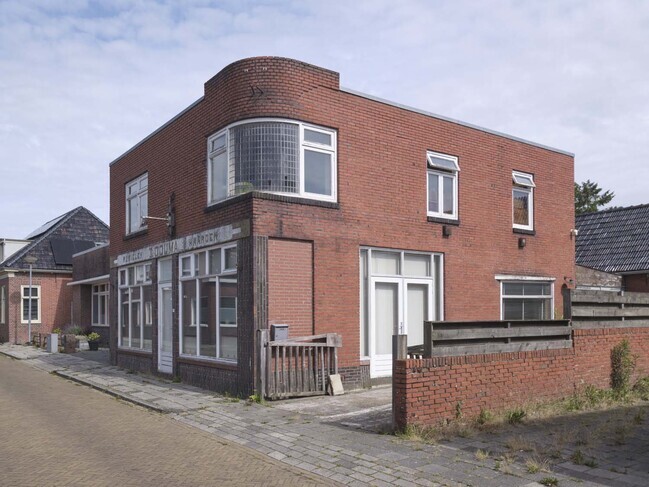 Het bescheiden winkel-woonpand.
<br/>
Johan van den Tol, 2024
