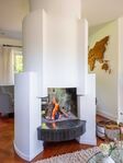 De bijzonder vormgegeven open haard in de woonkamer.
              <br/>
              Croon Makelaars, 2025