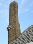 Karakteristieke bakstenen schoorsteen met betonnen elementen.
<br/>
Gert-Jan Lobbes, 2023
