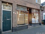 De winkelpui uit teakhout met links de voordeur naar de woning.
<br/>
Gert-Jan Lobbes, 2025