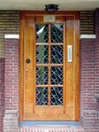 De monumentale voordeur is voorzien van glas-in-lood met gelijke motieven als de hal.
<br/>
Gert-Jan Lobbes, april 2023
