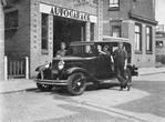 Auto- en taxibedrijf Dijkstra in de Emmastraat. Achter de auto staat Piet Dijkstra, voor de auto Berend Dijkstra.
<br/>
Fotoarchief Oud Meppel, fotograaf: Bert Klinge, begin jaren 50
