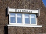 De naam van de villa in sierlijke, losse, Amsterdamse School letters.
              <br/>
              Gert-Jan Lobbes, 2025