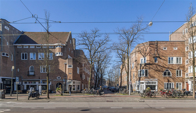 Blik in de IJselstraat vanuit de Rijnstraat. Aan weerszijden de hier besproken blokjes van Boterenbrood.
              <br/>
              Marcel Westhoff, 2021