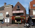 Het oog wordt getrokken door de winkelpui, het pand zelf is doorsnee architectuur.
<br/>
Gert-Jan Lobbes, 2022