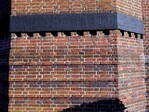 Detail gevel met opvallend metselwerk en een betonnen band.
              <br/>
              Gert-Jan Lobbes, 2024