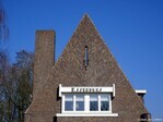 De eerste en zolderverdieping. Links een zeer hoge, smalle schoorsteen.
              <br/>
              Gert-Jan Lobbes, 2025