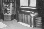 De vitrinekast en de radiatorombouw.
<br/>
Detail foto 2, omstreeks 1920