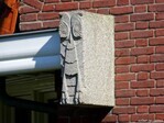 Uitgehouwen uilen flankeren de ingang.
              <br/>
              Gert-Jan Lobbes, 2024