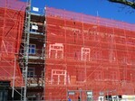 In de steigers. De nieuwe kozijnen staan klaar.
              <br/>
              Gert-Jan Lobbes, 2025